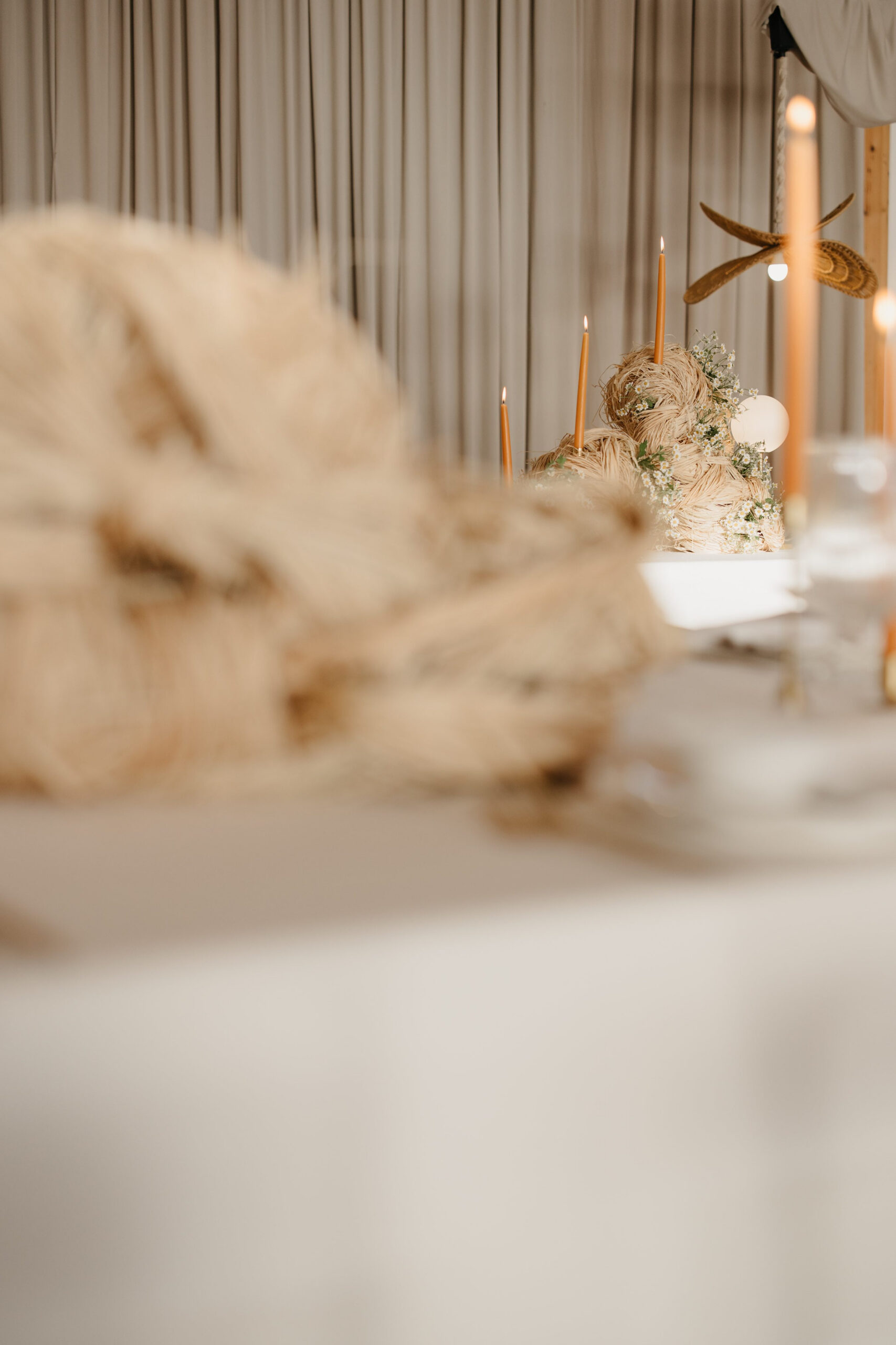 Elegant wedding table styling with sculptural raffia décor, warm taper candles, globe lighting and delicate florals by a|CREATE
